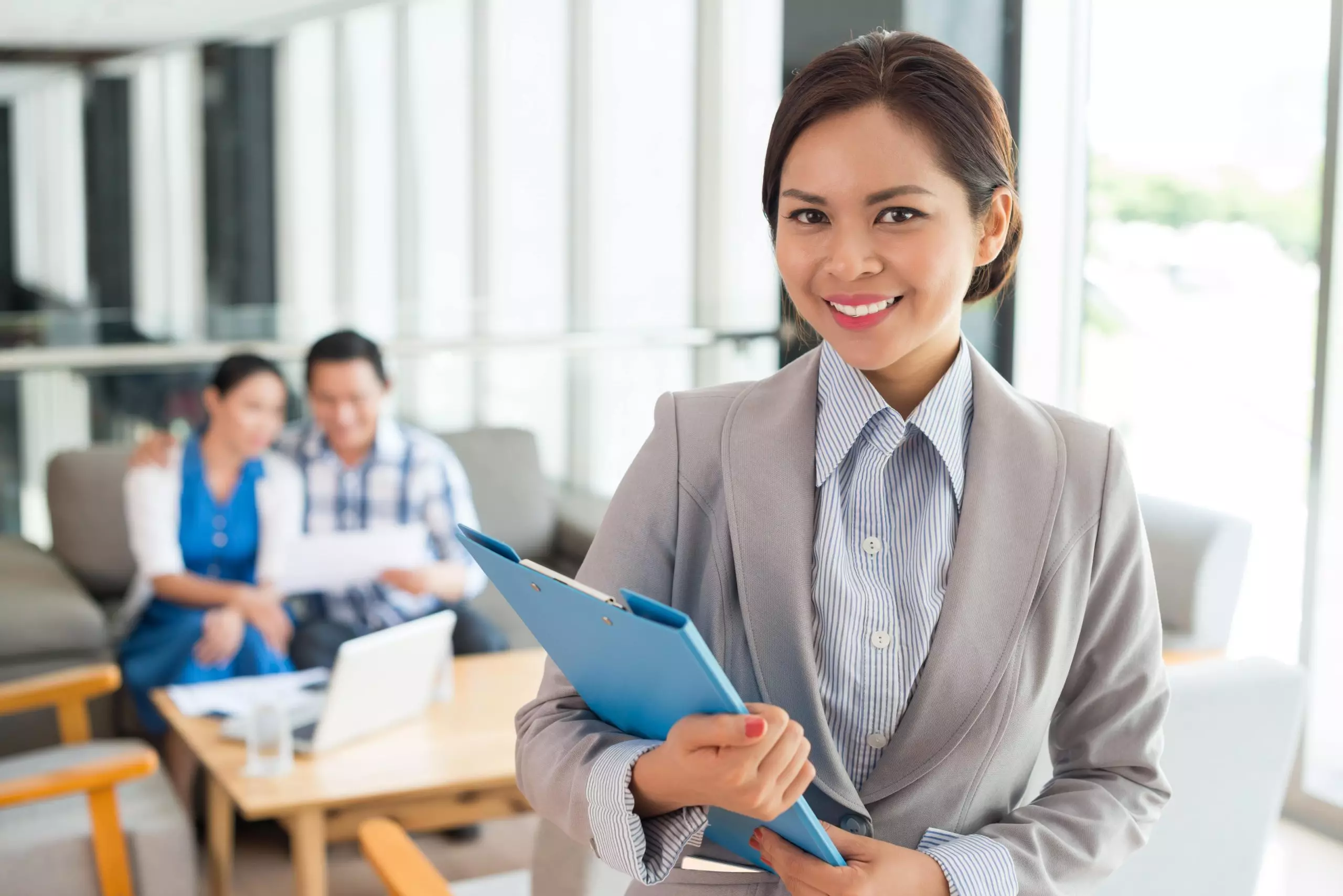 Portrait of cheerful real estate agent with a clipboard